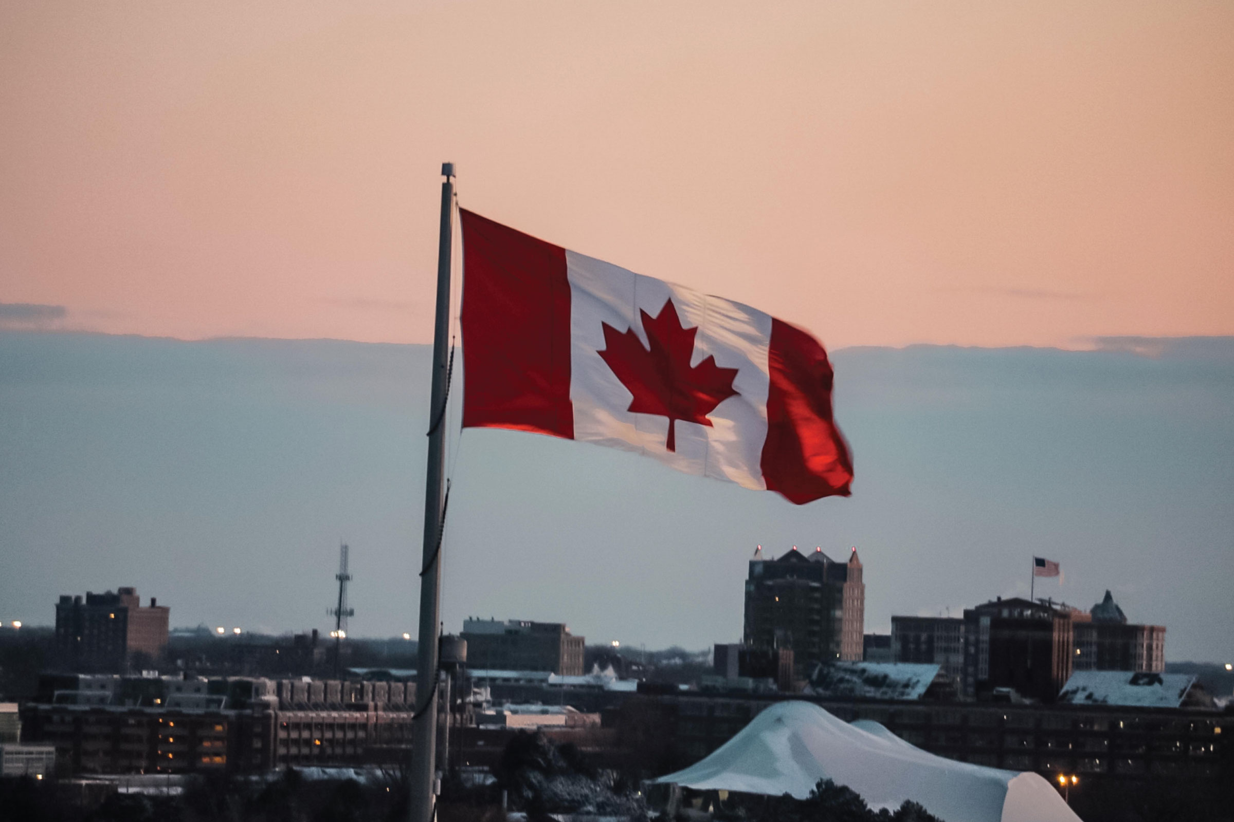 Canadian flag over landscape.